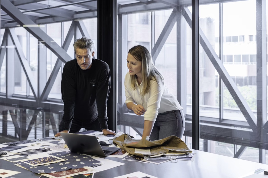 Two colleagues reviewing documents at a long table