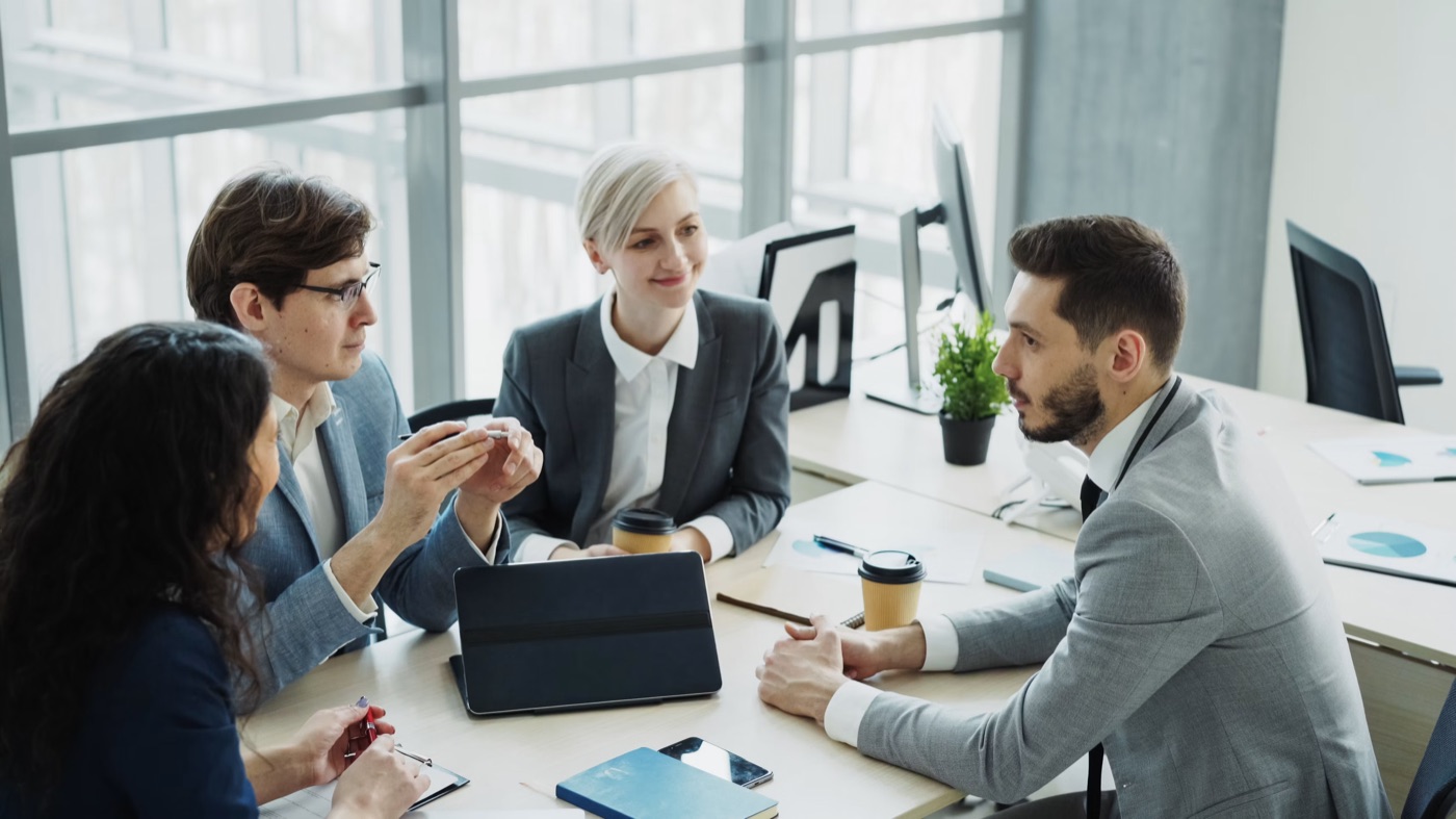 Four members of the FBGM team in a working session around a desk