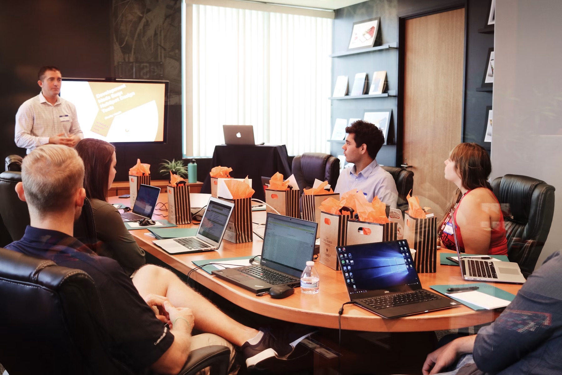 A presenter leading a training session for a group at a conference table
